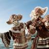 masked performers on a dock